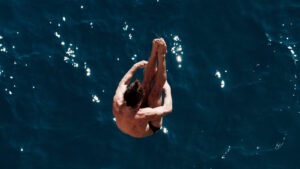 Cliff Diving – Der spektakuläre Sprung von der Klippe 7 Das Bild zeigt einen Springer beim Cliff Diving, der kurz vor dem Wassereintritt steht.