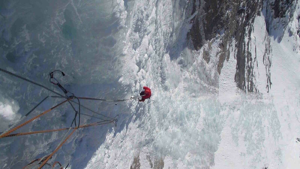 Eisklettern: Technik, Ausrüstung, Eisverhältnisse und Sicherheit an Eisfällen 1 Im Bild sieht man eine Person beim Eisklettern, der sich gerade von einem Hang abseilt