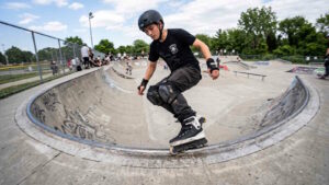 Inline-Skating lernen: 10 wichtige Tipps für Anfänger 1 Das Bild zeigt einen jungen Mann beim Inline-Skating in einem Skatepark