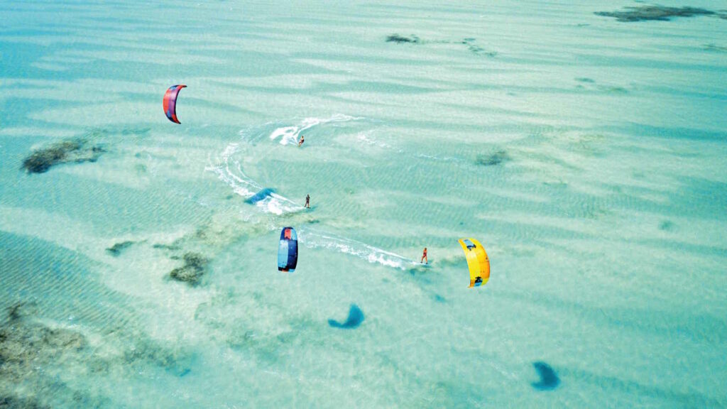Kitesurfen: Der umfassende Guide für Einsteiger und Fortgeschrittene mit Tipps 4 Das Bild zeigt mehrere Kitesurfer im Meer