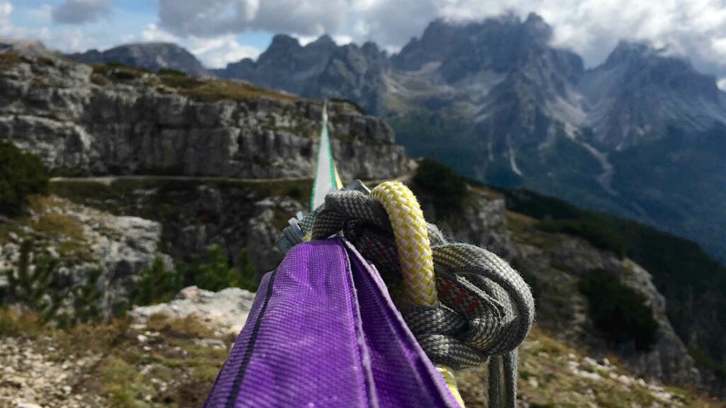 Slacklining: 10 Tipps, Vorteile & Arten erklärt 2 Das Bild zeigt eine Highline, die für Slacklining in den Alpen in großer Höhe zwischen zwei Bergen abgespannt ist.