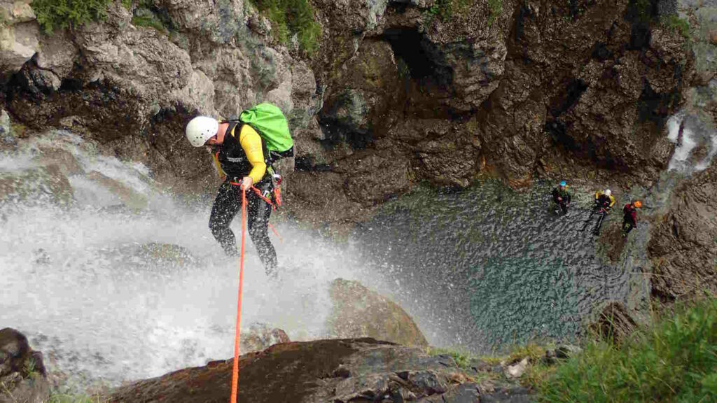 Canyoning: Die besten Tipps für ein sicheres Abenteuer 4 Canyoning erleben in einer Gruppe beim Abseilen von einer Felswand